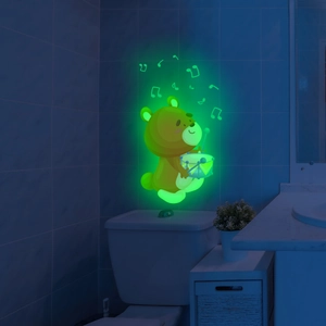 Luminous wall sticker showing a glowing cartoon bear and music notes in a dark bathroom