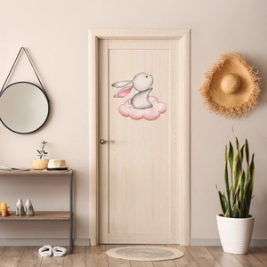 Cute bunny on pink cloud wall sticker applied on a minimalist wooden door decor