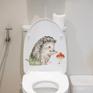 Detailed watercolor hedgehog and mushroom decal applied to a modern toilet lid