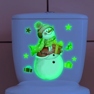 Glow-in-the-dark Christmas snowman toilet sticker glowing in dark bathroom setting