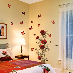 Dettaglio degli adesivi murali con rose rosse 3D e farfalle in una camera da letto