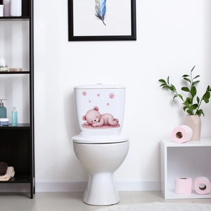 Glow-in-the-dark sleeping bear and pink stars decorative sticker on white toilet tank