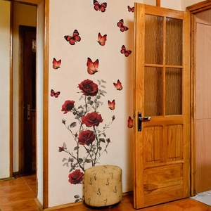 Dettaglio di adesivi murali con rose rosse e farfalle decorative su una parete interna