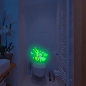 Glow in the dark bunny and butterfly wall decals glowing with green light in a bathroom
