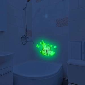 Luminous wall sticker showing glowing green bunnies and butterflies in a dark bathroom