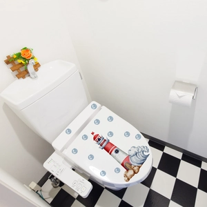 Detailed lighthouse and ocean waves pattern decal applied on a modern white toilet lid