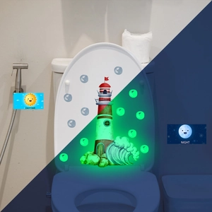 Luminous lighthouse toilet sticker showing daytime view and glowing green night effect