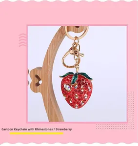 Detailed macro view of the rhinestone strawberry keychain with gold-plated metal ring buckle