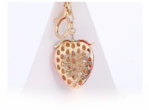 Detail of red hollow strawberry keychain with golden plating and lobster clasp