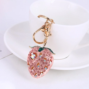 Glittering strawberry keychain with pink rhinestones and gold lobster clasp on white cup