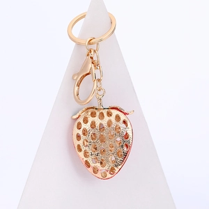 Golden metal strawberry keychain with hollow carving and sparkling crystal accents