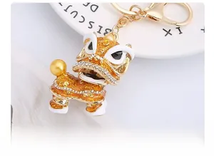 Close-up detail of Chinese lion dance keychain with gold enamel and sparkling rhinestones