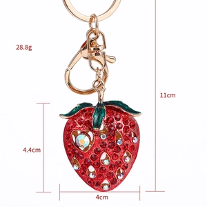 Red rhinestone strawberry keychain with gold plating and green leaf detail for bags