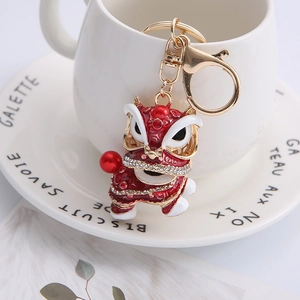 Detailed close-up of a red Chinese lion dance keychain with rhinestones and pearl