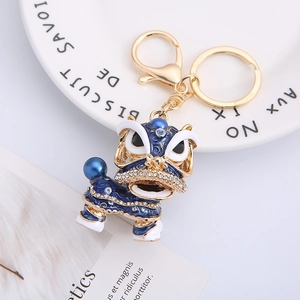 Exquisite gold-plated Chinese lion dance keychain with blue enamel and white rhinestones
