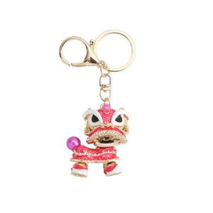 Traditional Chinese lion dance keychain with red enamel, gold plating, and rhinestones