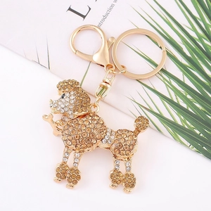 Gros plan d'un porte-clés caniche en or champagne avec strass brillants et mousqueton