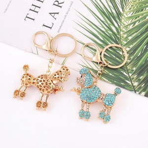 Porte-clés caniche coeur doré et chien en strass bleus sur fond blanc avec décoration