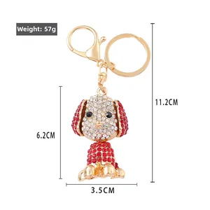 Cartoon dog keychain with sparkling white and red crystals on a golden clasp