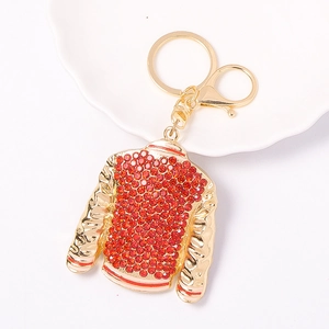 Macro shot of gold-tone sweater keychain featuring red rhinestones and lobster clasp
