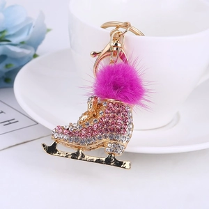Détail d'un porte-clés patin à glace avec strass brillants et pompon en fourrure rose