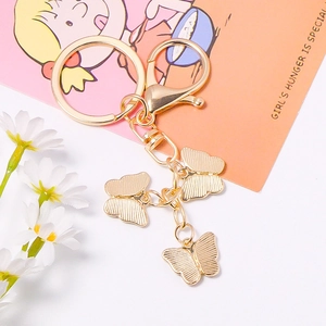 Golden butterfly keychain with lobster clasp on floral card, creative luxury backpack gift