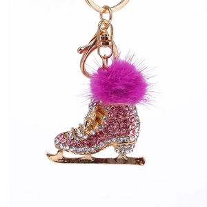 Détail du porte-clés patin à glace avec strass roses et blancs et pompon en fourrure