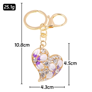 Goldener Herz Schlüsselanhänger mit lila Blumendekor und Maßen 10,8x4,5x4,3cm
