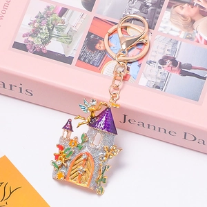 Détail du porte-clés château argenté pailleté avec tours violettes et petite fée