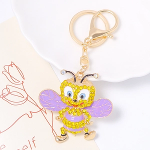 Détail du porte-clés abeille avec strass jaunes et ailes lavande sur base dorée