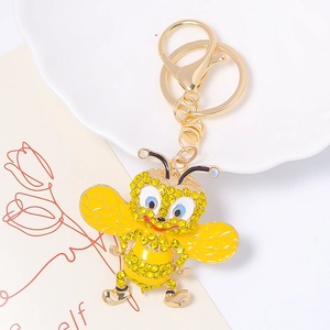 Détail macro du porte-clés abeille avec strass jaunes sur une base en alliage doré