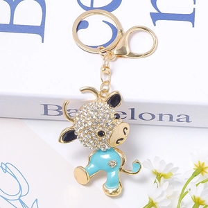 Detail of blue enamel ox keychain with white rhinestones and gold-plated lobster clasp