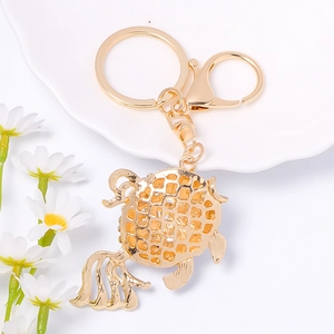 Porte-clés poisson rouge doré avec design ajouré sur assiette blanche et marguerites