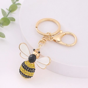 Détail d'un porte-clés abeille avec des strass jaunes et noirs et un anneau doré