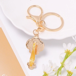 Golden koi fish Ruyi keychain with horseshoe buckle on an elegant ceramic plate