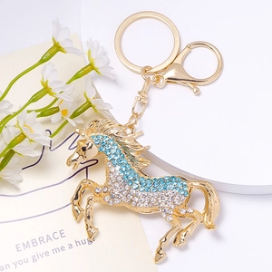 Vue macro d'un porte-clés cheval doré serti de strass brillants bleu clair et blancs