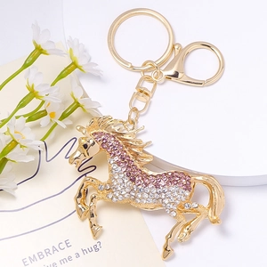 Détail du porte-clés cheval doré avec strass scintillants en dégradé de rose et de blanc