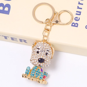 Dettaglio del portachiavi a forma di cane con strass bianchi e blu e finitura oro