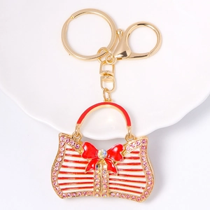 Golden handbag keychain with red stripes, bow tie and sparkling rhinestones