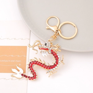 Detailed macro view of the golden dragon keychain with red and white crystal rhinestones