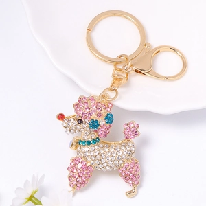 Détail d'un porte-clés caniche en métal doré avec cristaux roses et fermoir homard