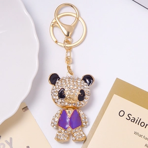 Close-up of a sparkling panda keychain with purple vest and inlaid rhinestones