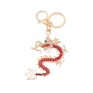 Macro detail of Chinese dragon keychain with red rhinestones and gold plating finish
