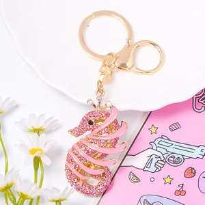 Gros plan d'un porte-clés hippocampe en strass rose avec cadre en métal doré poli