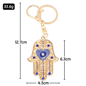 Hamsa hand metal keychain with blue rhinestones and evil eye heart charm detail