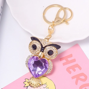 Détail du porte-clés hibou avec gemme cœur violette et strass blancs brillants