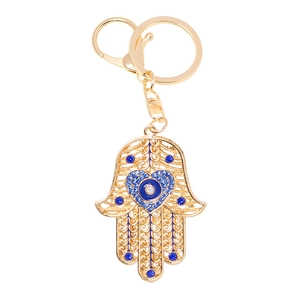 Golden Hamsa hand keychain with blue rhinestones and Evil Eye heart shaped design