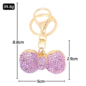 Golden rhinestone bowknot keychain with purple crystals and dimensions 8.8cm by 5cm