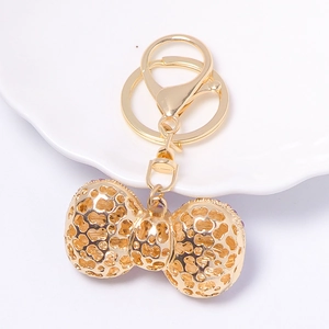 Golden hollowed-out metal bow keychain with purple crystals and lobster clasp hook