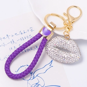 Purple woven leather keychain with rhinestone lip charm and heart pendant in gold finish